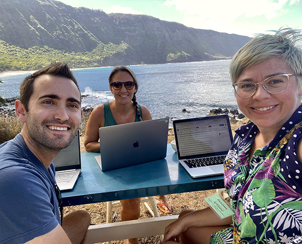 Robin Tinghitella (center) and her fellow researchers work at a table on their computers in Hawaii.