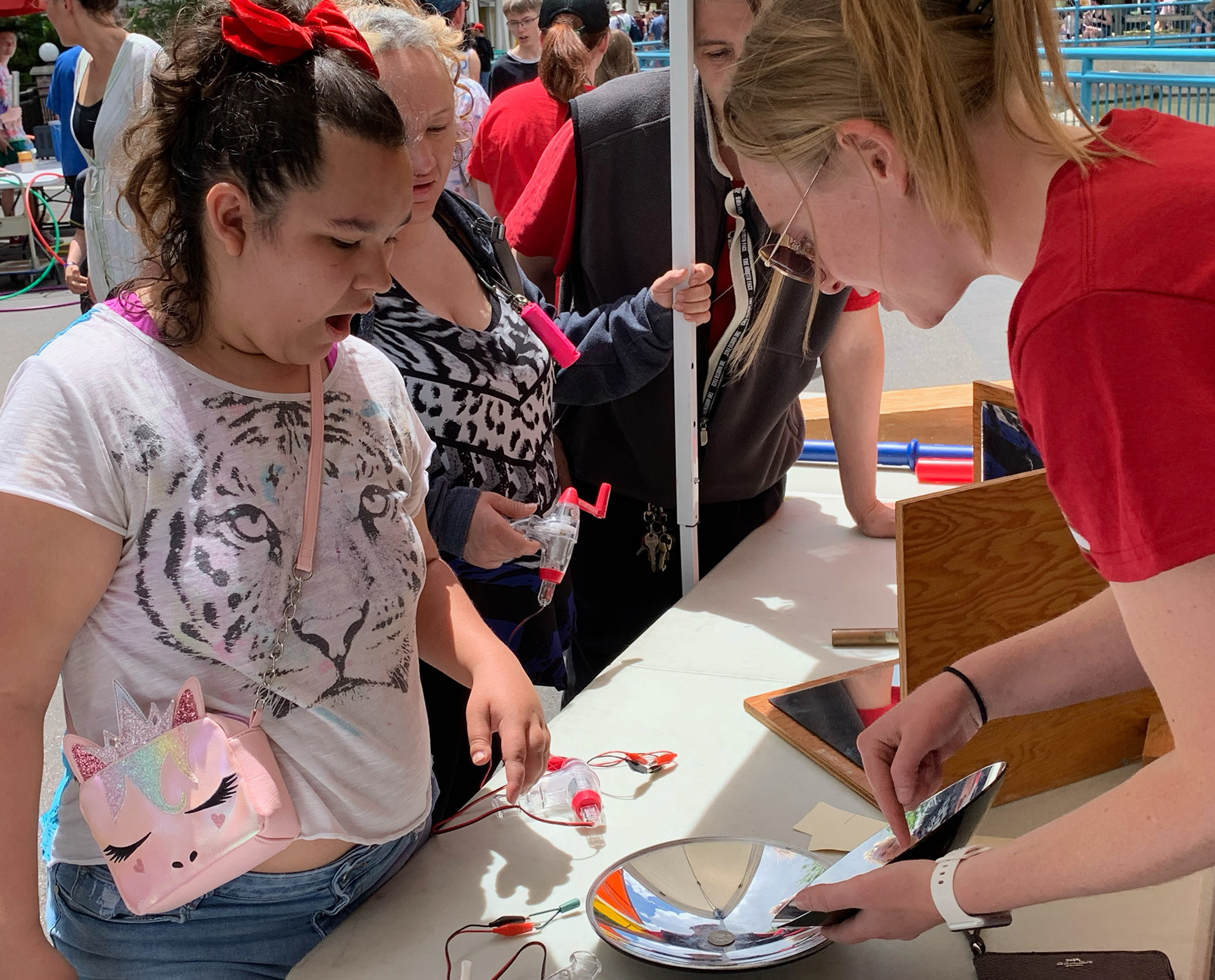 College student demonstrating experiment for elementary student