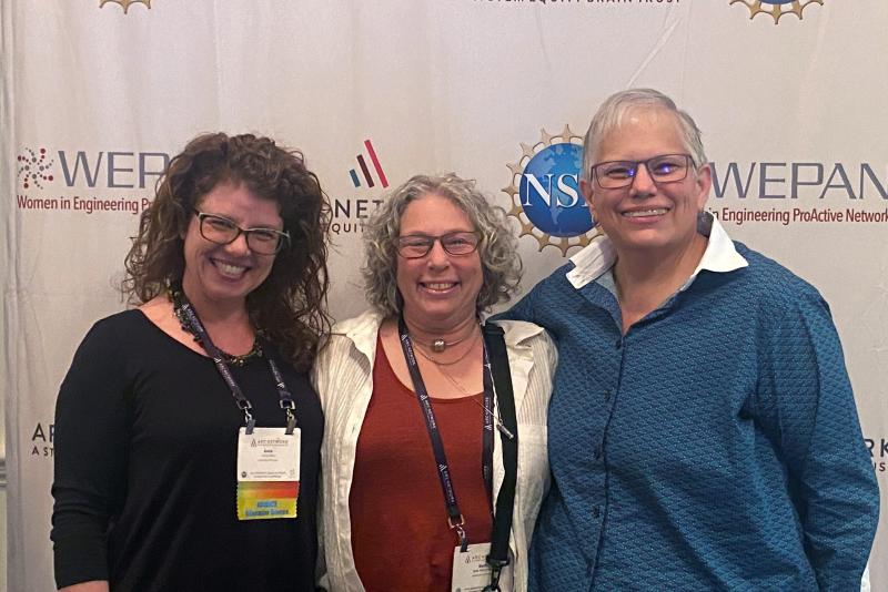 3 people in a line in front of a backdrop
