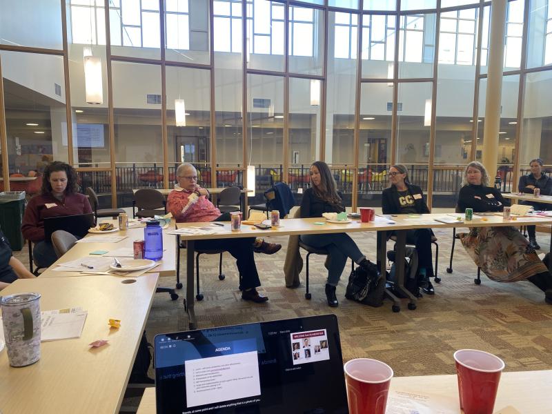 a group of faculty gathers around in discussion
