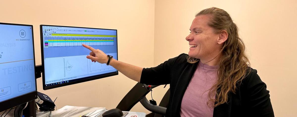 Professor pointing at graph on computer screen in medical lab